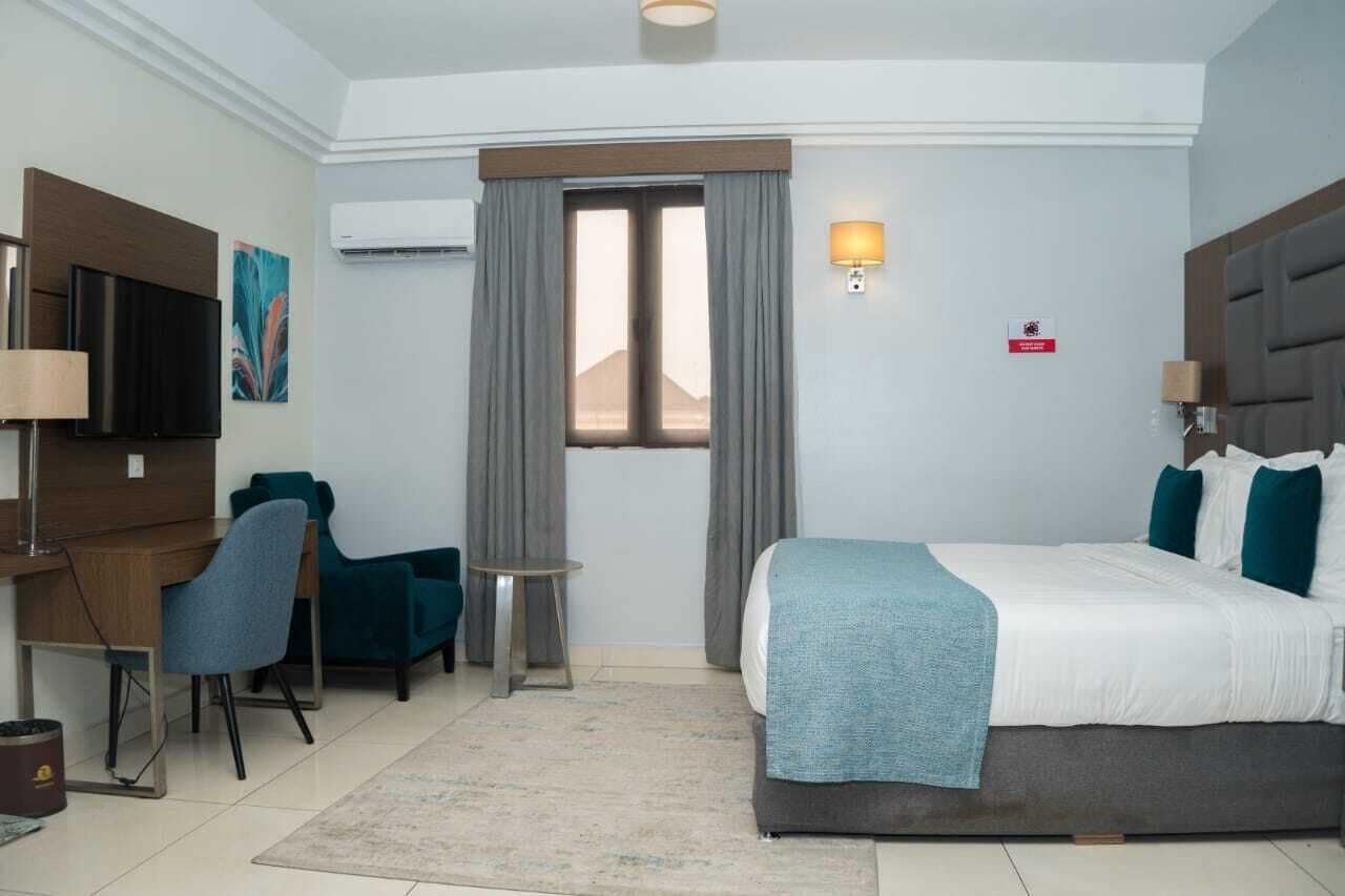 Deluxe Room with king bed, desk and armchair