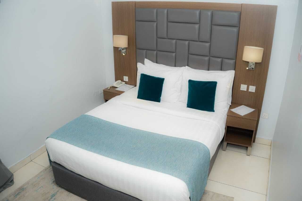 Standard Room bed with teal cushions